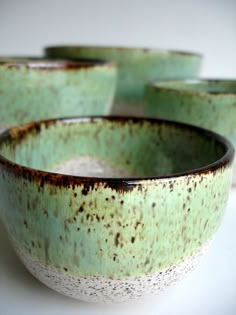 four green and white bowls sitting next to each other