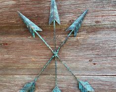 three metal arrows on top of a wooden surface