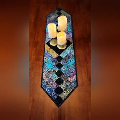 three candles are placed on top of a tie