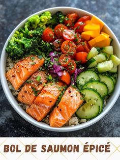 a bowl filled with salmon, cucumbers, tomatoes and broccoli on top of rice