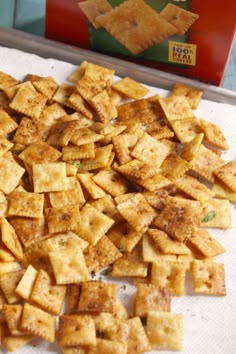 some crackers sitting on top of a white towel next to a box of chips