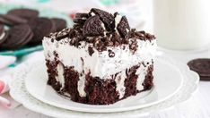 a close up of a cake on a plate with cookies and milk in the background