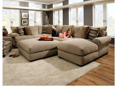 a woman laying on top of a couch in a living room