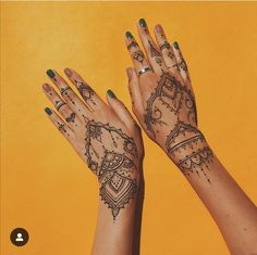 two hands with henna tattoos on them