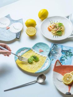 a person is eating some food on a plate with lemons and other items around it