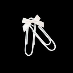 two white paper clips with a bow on the top and one has a black background