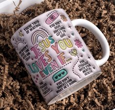 a white coffee mug sitting on top of wood shavings with the words jesus you loves it