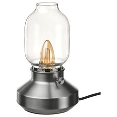 a light that is on top of a metal base with a glass dome over it