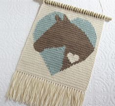 a crocheted rug with a horse on it and a heart in the center