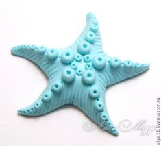 a blue starfish is sitting on a white surface and has buttons in the shape of circles