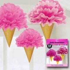 three ice cream cones with pink flowers hanging from the ceiling in front of a window