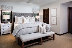 a bedroom with a large bed and white furniture