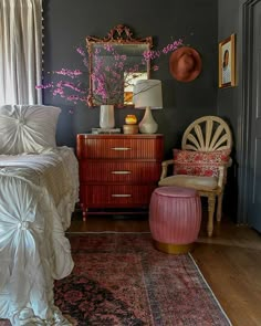 a bed room with a neatly made bed and a chair next to a mirror on the wall