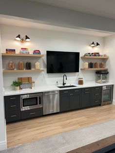 a kitchen with black cabinets and stainless steel appliances