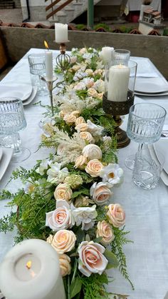 a long table with candles and flowers on it