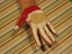 a hand that has been decorated with white paint and red santa claus's hat