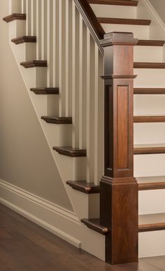 an empty staircase with wooden handrails and wood flooring in a new home