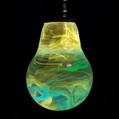 a light bulb that has been painted green and yellow with blue swirls on it