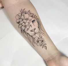 a woman's arm with a lion and flowers on it