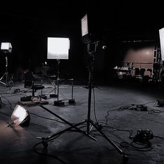 several lights are set up in a dark room with other lighting equipment on the floor