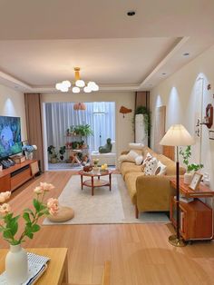 a living room filled with furniture and a flat screen tv sitting on top of a hard wood floor