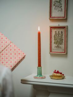 a lit candle sitting on top of a white table