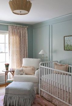 a baby's room with blue walls and white furniture