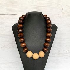 This chunky wood necklace was hand beaded using a mix of large 25mm round dark brown and 28mm round medium tone tan wooden beads in a modern color block design. The necklace measures 24 inches long and is securely fastened with a silver clasp.  Perfect for any gender!  Length can be adjusted if needed - just ask! Wood represents a sense of earthiness, spirituality, creativity, liberty, prosperity, health, and natural touch.  Perfect for meditation, prayer, yoga practices, and everyday wear!    C Rustic Brown Wooden Bead Necklaces, Brown Wooden Beaded Jewelry, Rustic Brown Necklace With Large Beads, Brown Wooden Necklace With Large Beads, Brown Wooden Beads Round Jewelry, Brown Wooden Beads Jewelry, Brown Round Wooden Beads Jewelry, Handmade Brown Beaded Necklaces, Handmade Brown Round Beaded Necklaces