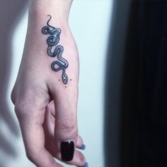 a woman's hand with a snake tattoo on it