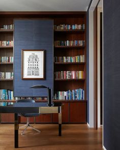 an office with bookshelves and a desk in front of the bookcases