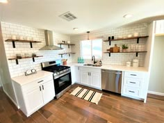 a kitchen with white cabinets and wooden floors