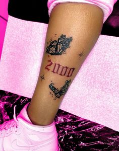 a woman's leg with butterflies and the word mom tattooed on it