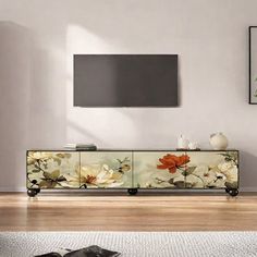 a living room scene with focus on the television and flowers painted on the sideboard