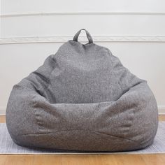 a bean bag chair sitting on top of a wooden floor next to a white wall