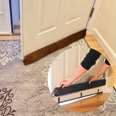 a woman is standing on the floor in front of a door with her legs up