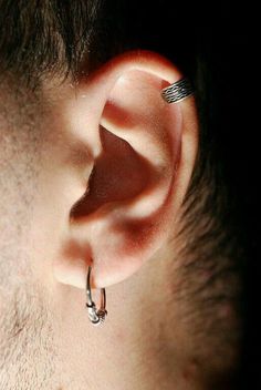 a close up of a man's ear with an earring attached to it