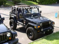 two jeeps are parked on the side of the road