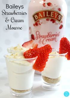 two small glasses filled with ice cream and strawberries next to a bottle of bailey's strawberry creme