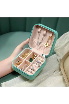 a woman's hand holding an open jewelry box