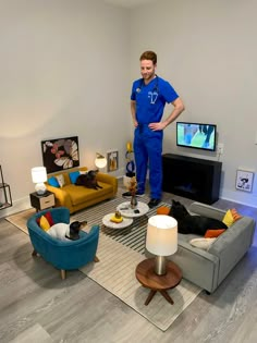 a man standing in the middle of a living room with two couches and a television