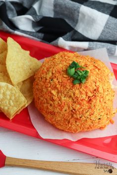 a red tray with some chips and a ball of food on it