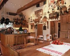 a large kitchen with wooden floors and lots of hanging utensils on the wall