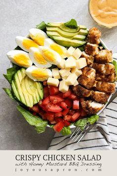 a salad with chicken, avocado and tomatoes