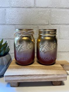 two mason jars sitting on top of a wooden stand