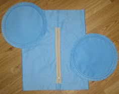 a pair of blue pads sitting on top of a wooden floor next to a piece of cloth