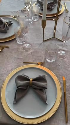 the table is set with plates, silverware and gold rimmed cutlery dishes