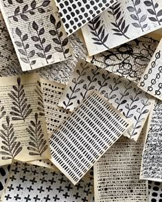 many different types of paper with black and white designs on them, all stacked together