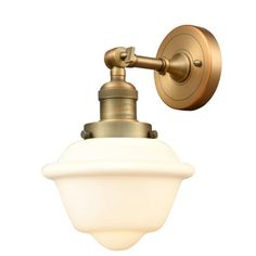 an antique brass wall light with a white glass shade