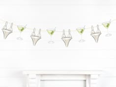 several martini glasses are lined up on a string