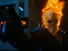 a skeleton with flames on his face and hands in the air, pointing at something